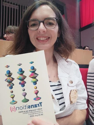Valériane Loison souriante, tenant une affiche dans ses mains